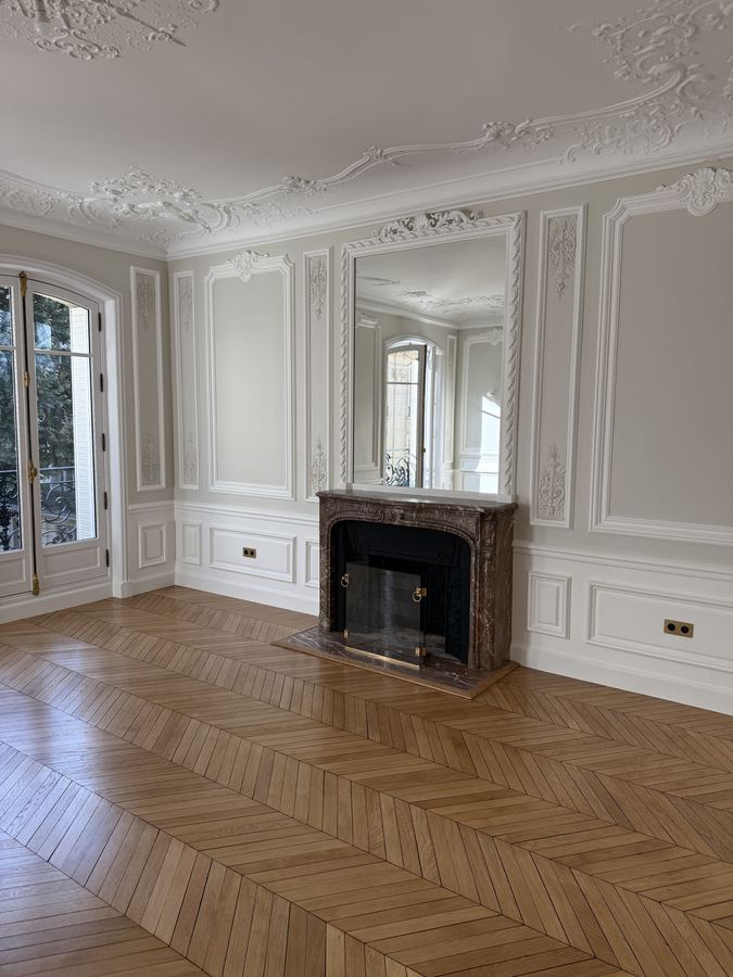 Salon haussmannien avec cheminée et parquet en point de Hongrie
